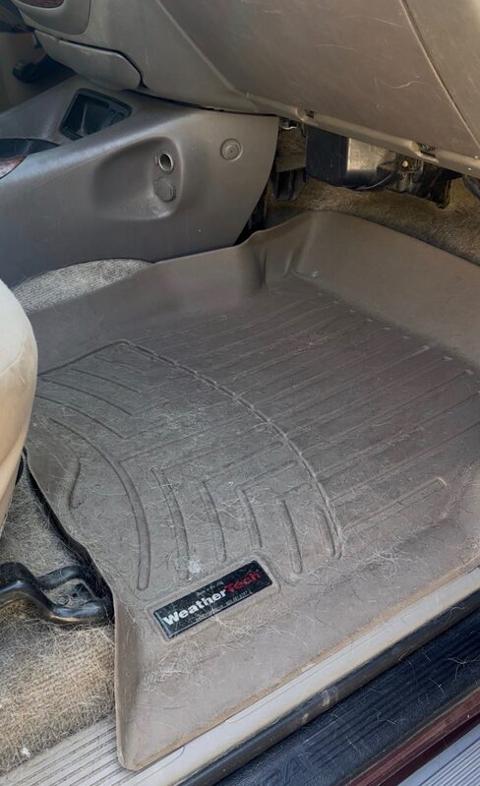 Dirty car floorboard covered in debris before interior detailing
