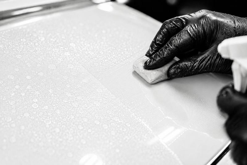 Clay bar decontamination on white car paint before polishing